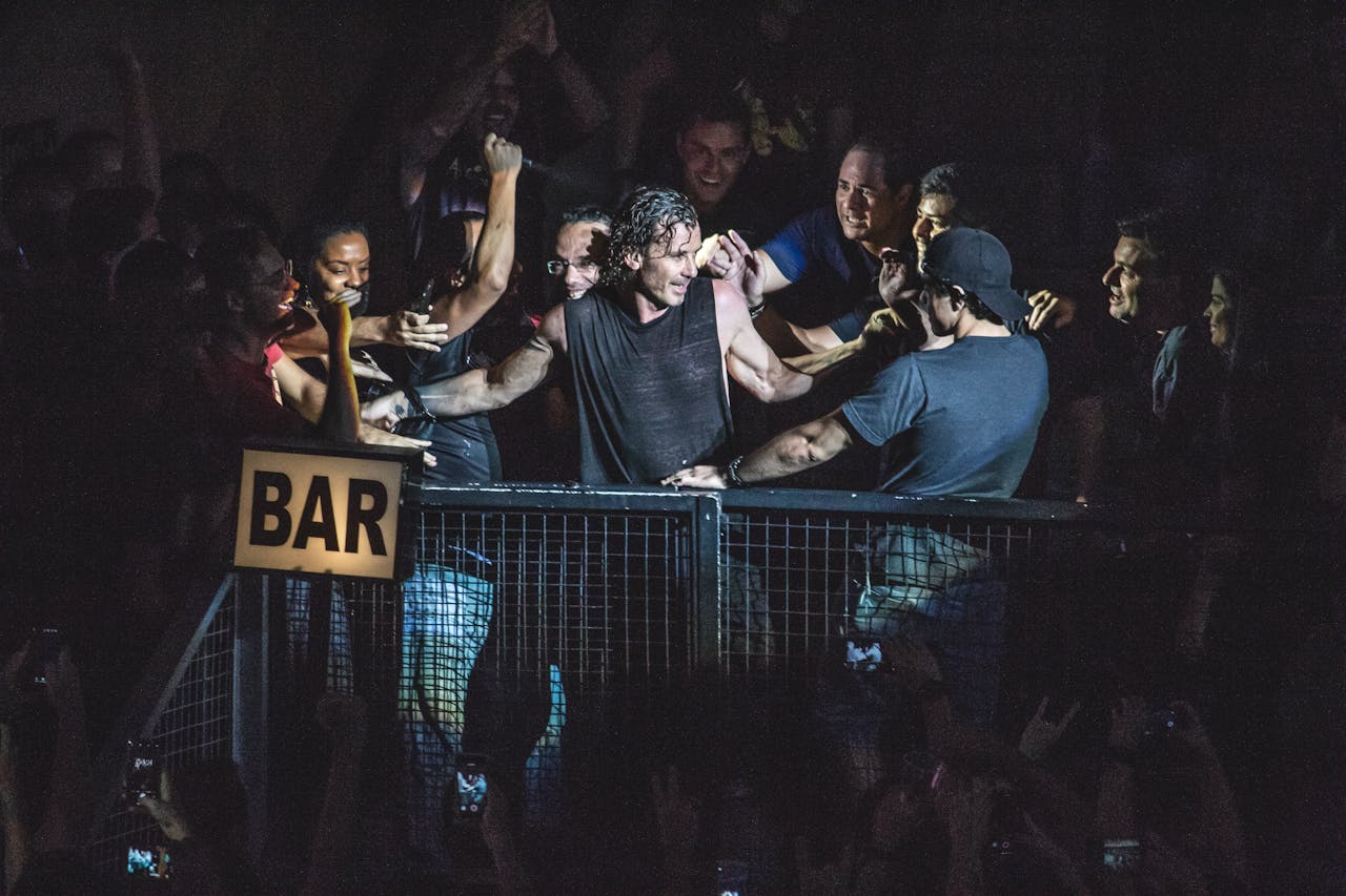 Excited audience enjoying a live concert with cheering and vibrant energy.